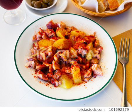 Boiled octopus tentacles with potatoes seasoned with smoked paprika Boiled octopus tentacles with potatoes seasoned with smoked paprika 101692379