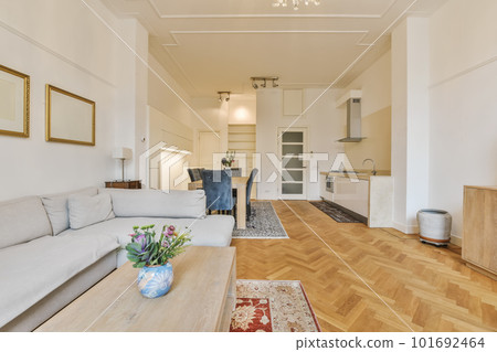 a living room with wood flooring and white sofas in the center of the room is a wooden coffee table 101692464