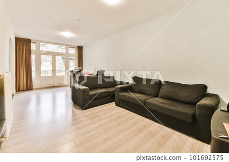 a living room with two couches and a coffee table in the center of the room is white painted walls 101692575