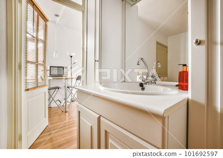 a bathroom with wood flooring and white walls, along with a large mirror in the corner of the room a bathroom with wood flooring and white walls, along with a large mirror in the corner of the room 101692597