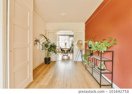 a living room with red walls and white trim on the walls there is an entry way that leads to another room a living room with red walls and white trim on the walls there is an entry way that leads to another room 101692758