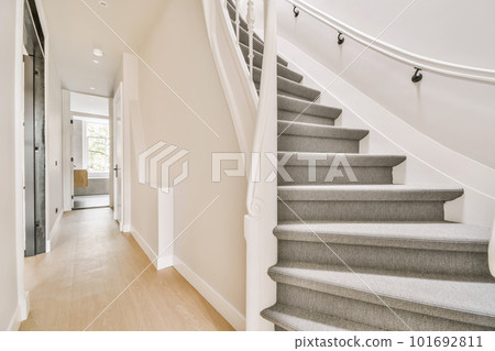 some stairs in a house with light wood flooring and white railings on the side of the staircase leading up to the second 101692811