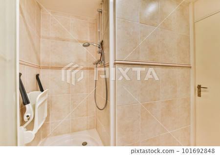 a bathroom with a shower and toilet paper dispensed on the wall next to it is an open door 101692848