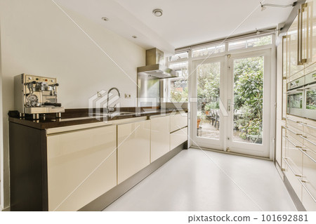 a modern kitchen with white cabinets and black counter tops in an open doord area that leads to the patio 101692881