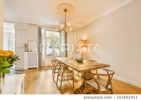 a dining table and chairs in a room with white walls, wood flooring and light fixtures on the wall 101692951