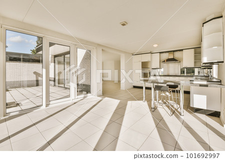 a kitchen and dining area with sliding glass doors that open to the backyard patio, which is white tiled flooring 101692997