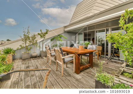 an outdoor living area with wooden decking, plants and potted pots on the table in front of the house an outdoor living area with wooden decking, plants and potted pots on the table in front of the house 101693019