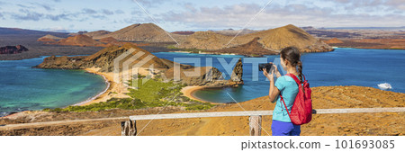 Galapagos islands ecotourism travel banner. Bartolome Island, tourist hiking in the Islas Galapagos archipelago. Panoramic view of Sullivan bay, golden beach and Santiago island on cruise excursion 101693085