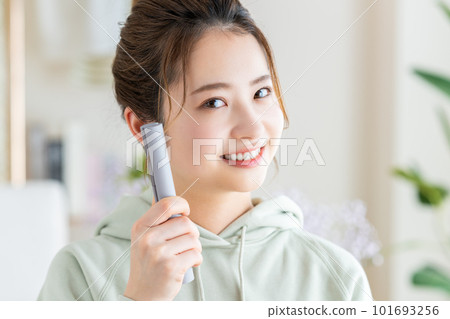 young woman doing hair set 101693256