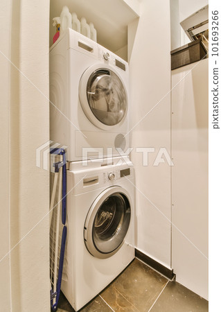 a laundry room with a washer and dryer on the floor in front of the washer's door 101693266