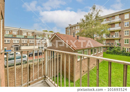 Panoramic view of brick buildings with parking and trees from small balcony Panoramic view of brick buildings with parking and trees from small balcony 101693524