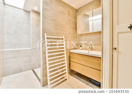 a modern bathroom with beige tile walls and white tiles on the wall, there is a towel rack next to the sink a modern bathroom with beige tile walls and white tiles on the wall, there is a towel rack next to the sink 101693530