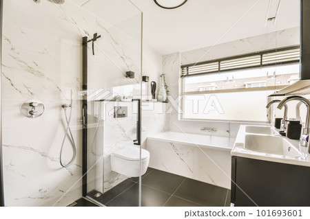 a modern bathroom with black and white marble tiles on the walls, shower stall and toilet in the corner area 101693601