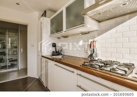 a kitchen with white tiles and wood counter tops on the counters in front of the stove, oven and dishwasher 101693605