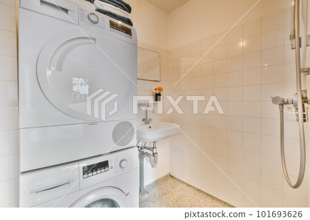 a laundry room with a washer, dryer and toiletries in the corner next to the shower stall 101693626