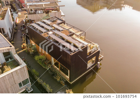 some houses that are floating in the water with their roofs and bales attached to the side of the house 101693754