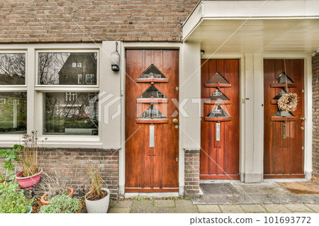 the outside of a house with plants in pots and bird houses hanging on the front door to make it look like they're the outside of a house with plants in pots and bird houses hanging on the front door to make it look like they're 101693772