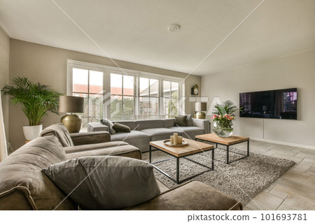 a living room with two couches and a large flat screen tv mounted on the wall in front of it 101693781