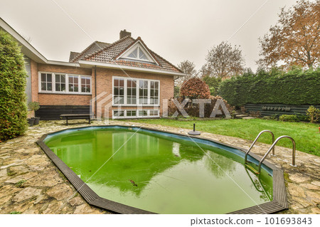 a house with a pool in the front yard and trees around it on a cloudy, overcast sky day a house with a pool in the front yard and trees around it on a cloudy, overcast sky day 101693843