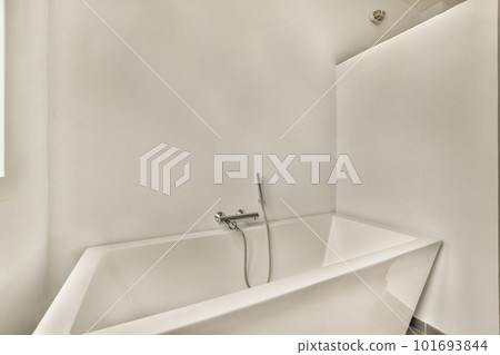 a bathtub in the corner of a bathroom with a sink and faucet next to it on the wall 101693844