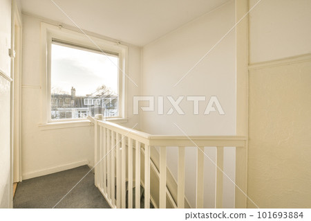 an empty room with white walls and grey carpeting on the floor in front of a large window looking out onto the street an empty room with white walls and grey carpeting on the floor in front of a large window looking out onto the street 101693884