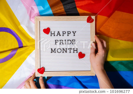 HAPPY PRIDE MONTH frame on Rainbow LGBTQIA flag made from silk material. Symbol of LGBTQ pride month. Equal rights. Peace and freedom. Support LGBTQIA community 101696277