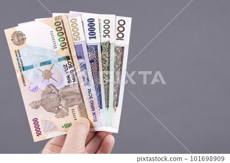 Old Uzbek money in hand on a gray background Old Uzbek money in hand on a gray background 101698909