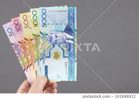 Old Turkmen money in the hand on a gray background 101698912
