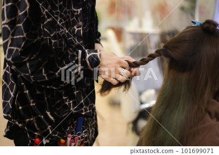 Male hairdresser tying woman's hair 101699071