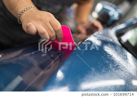 The master in the car service applies an armor film to the car. The master in the car service applies an armor film to the car. 101699714