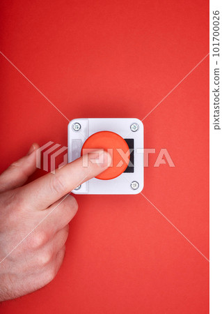 The hand, which pushes the emergency button at the red background at the top view 101700026