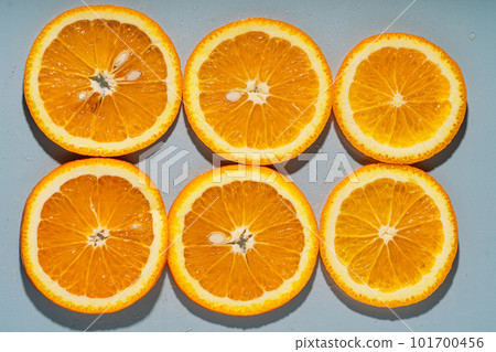 Round slices of orange on a gray background Round slices of orange on a gray background 101700456