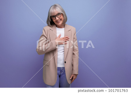 kind middle-aged woman in a jacket shows a heart with her hands on a bright background with copy 101701763