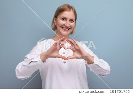 kind pleasant blond mature woman with clean face at menopause age in studio background 101701765