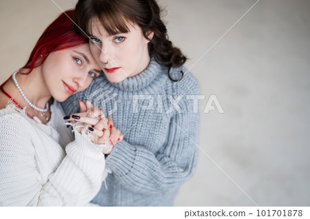 Portrait of two tenderly hugging women dressed in sweaters. Lesbian intimacy. Portrait of two tenderly hugging women dressed in sweaters. Lesbian intimacy. 101701878