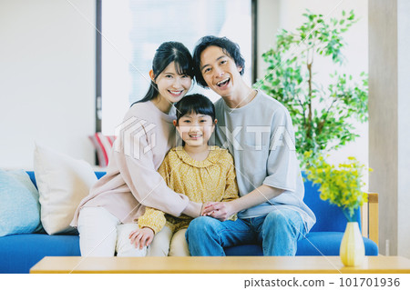 一個在客廳裡放鬆的年輕家庭 101701936