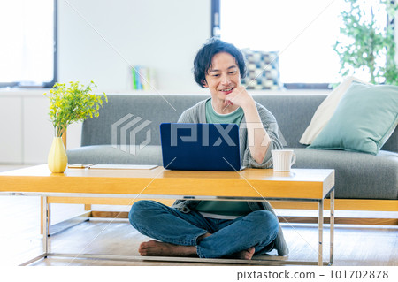 A man who uses a personal computer in the living room 101702878