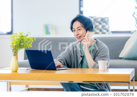 A man who uses a personal computer in the living room 101702879