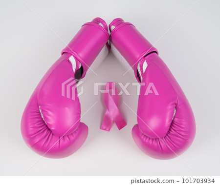 Pink boxing gloves and a pink silk ribbon on a white background. Breast cancer concept. Pink boxing gloves and a pink silk ribbon on a white background. Breast cancer concept. 101703934