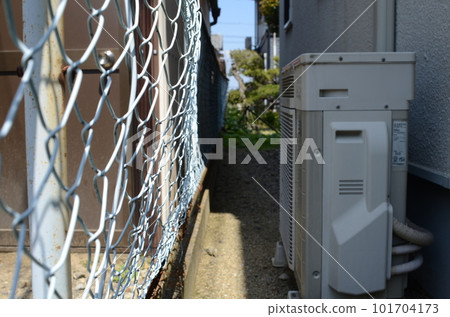 A dimly lit outdoor passageway in a residential building. Gap 101704173
