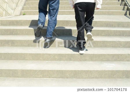 A man and a woman are walking up the stairs. A man and a woman are walking up the stairs. 101704178