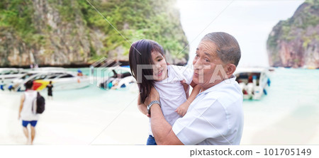 Happiness travel with Grandfather holding granddaughter to travel to the ocean beach during school holidays. Golden time of the elderly with family Happiness travel with Grandfather holding granddaughter to travel to the ocean beach during school holidays. Golden time of the elderly with family 101705149