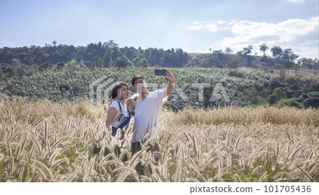 Snapping selfies of asian couple with mobile phone 101705436