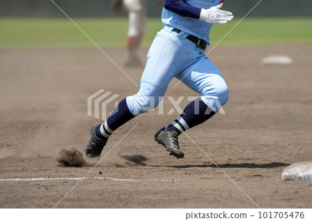 A runner aiming for the next base during a baseball game A runner aiming for the next base during a baseball game 101705476