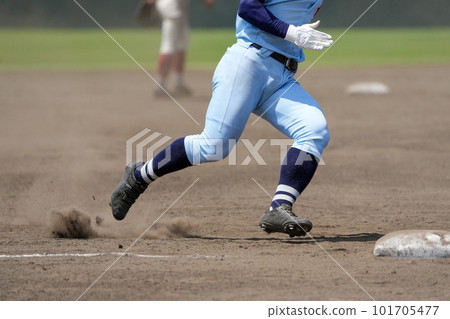 A runner aiming for the next base during a baseball game A runner aiming for the next base during a baseball game 101705477