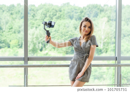 Young business woman recording video blog on smartphone in company office Young business woman recording video blog on smartphone in company office 101705731