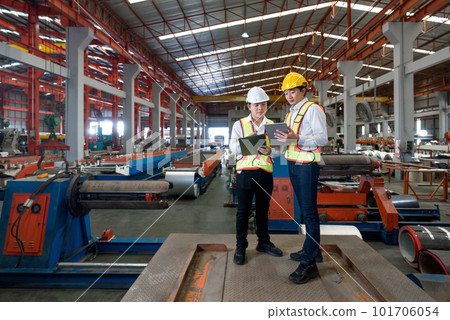 Young asian engineer manager trains new employees within the metal sheet factory. Everyone wear safety vest and hardhat. Various kind of industrial machine are in the working area. Young asian engineer manager trains new employees within the metal sheet factory. Everyone wear safety vest and hardhat. Various kind of industrial machine are in the working area. 101706054