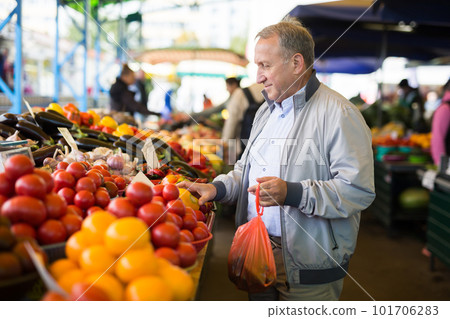 Man purchasing peppers in greengrocery Man purchasing peppers in greengrocery 101706283