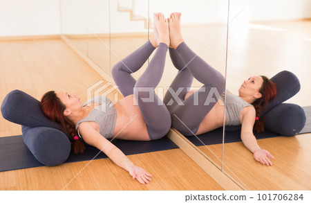 Pregnant woman is engaged in yoga. Bent Candle Pose or Viparita Karani Pregnant woman is engaged in yoga. Bent Candle Pose or Viparita Karani 101706284