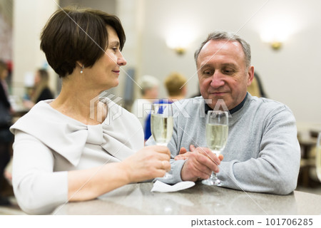 Mature man and woman drinking champagne in theater lobby Mature man and woman drinking champagne in theater lobby 101706285